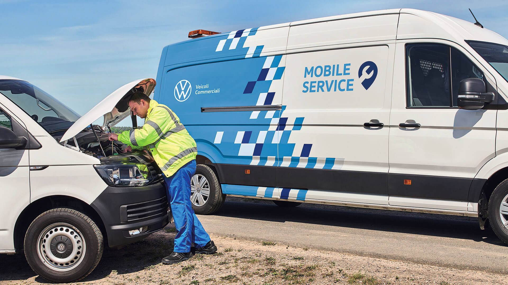 Uomo in piedi davanti a cofano aperto accanto a Mobile Service Unit