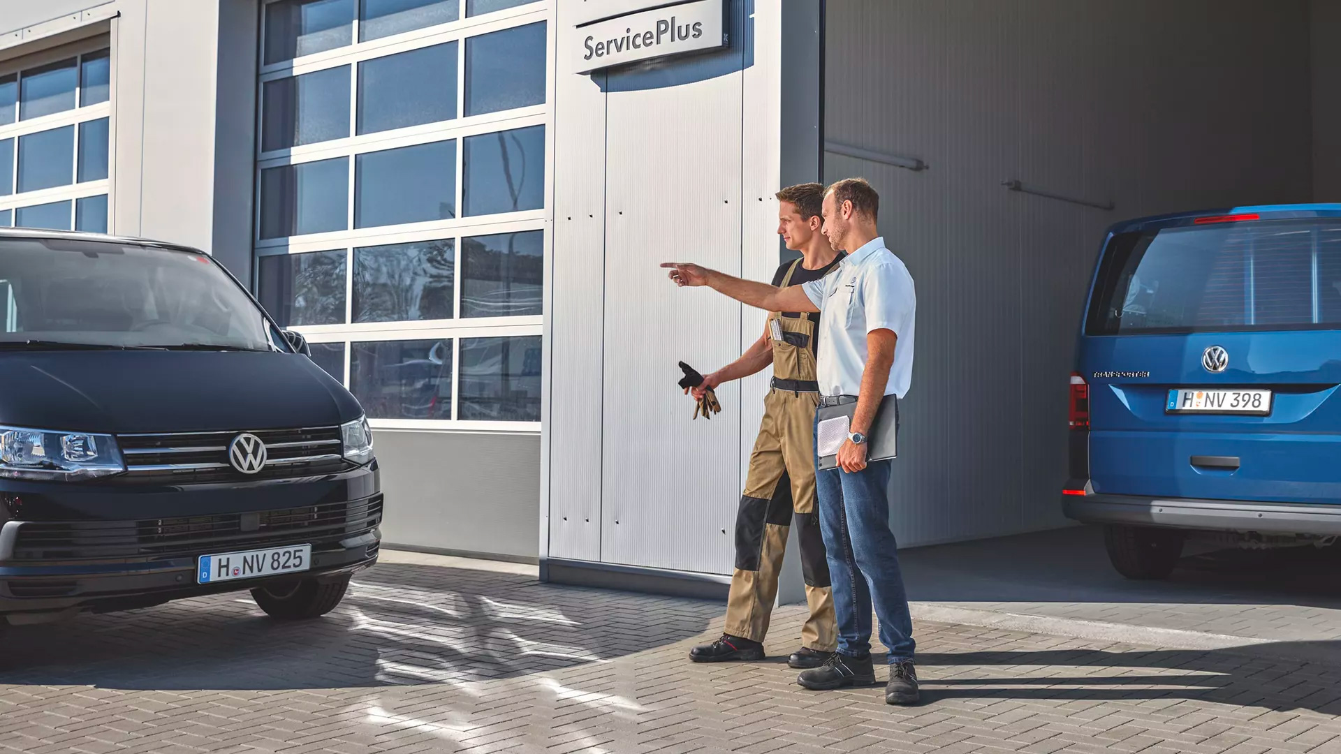 ServicePlus Meccanico e venditore che parlano davanti ad un Volkswagen Veicolo Commerciale