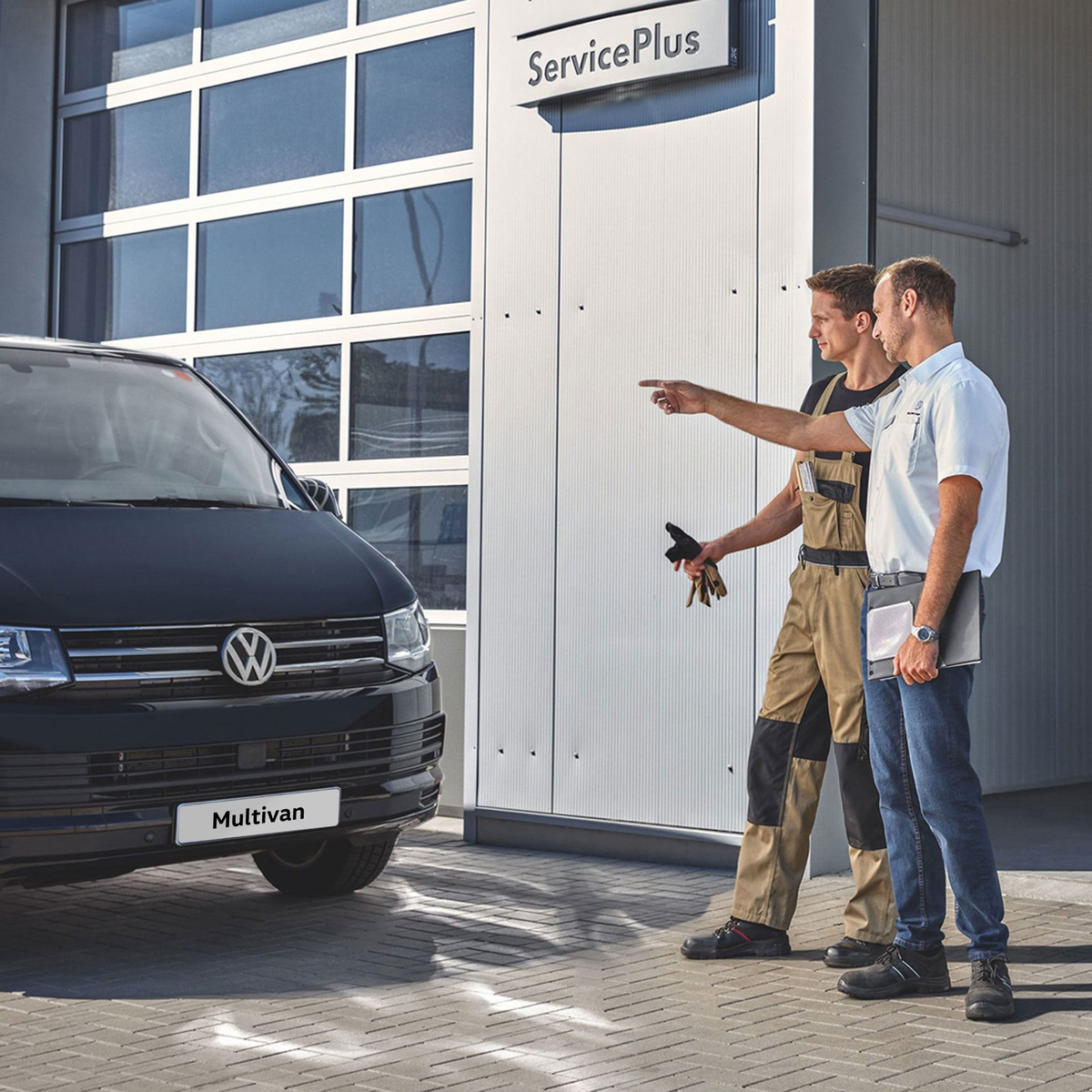 ServicePlus Meccanico e venditore che parlano davanti ad un Volkswagen Veicolo Commerciale